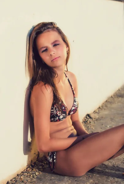 Hermosa Chica Joven Traje Baño Bikini Brillante Sentado Cerca Pared —  Fotos de Stock