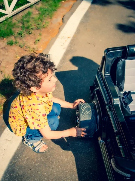 Junge Beim Reifenwechsel Einem Schwarzen Spielzeugauto Kinder Städtischen Freizeitpark — Stockfoto