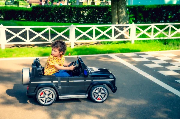 Netter Jähriger Junge Gelbem Hemd Fährt Auf Einem Schwarzen Elektroauto — Stockfoto