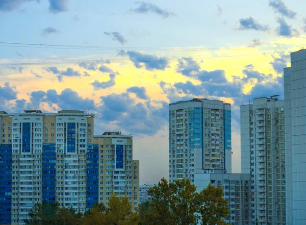 Moskova, Rusya 30 Ağustos 2018: Akşam gökyüzü ile güzel şehir manzarası, parlak güneş çok katlı binalar arasındaki bulutların arasından doğuyor.