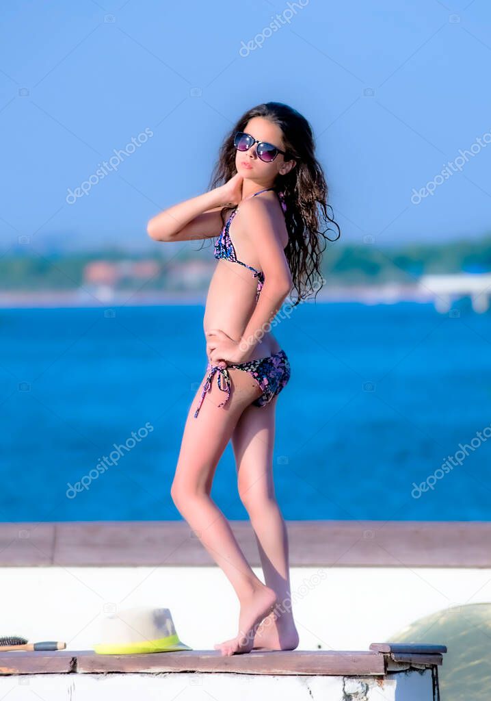 Funny young girl in a swimsuit against the sky