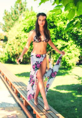 Tropik bölgelerde mayo giymiş uzun saçlı bir kız.