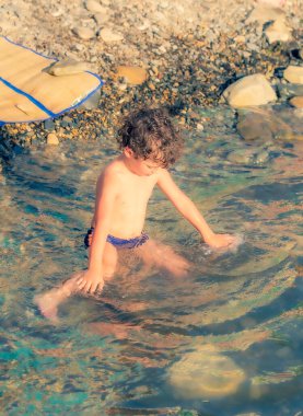 Anapa 'da plajda oynayan üç yaşında bir oğlan çocuğu.