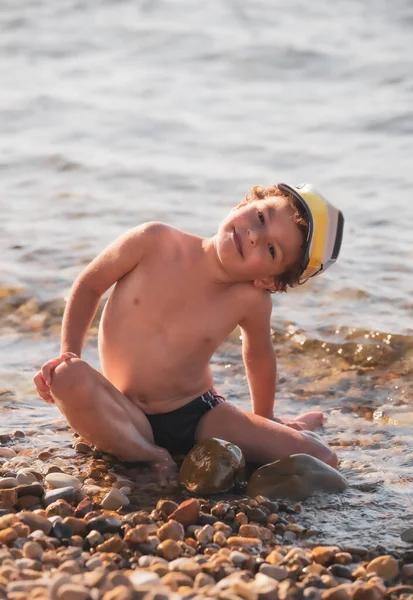 Kleine Jongen Een Kiezelstrand Een Jongetje Zit Het Strand Kijkt — Stockfoto