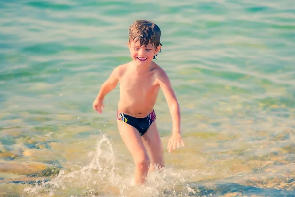 Jongen Lacht Speelt Het Strand Zijn Zwembroek — Stockfoto
