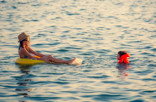 Два Счастливых Брата Сестра Отдыхают Море Улыбающаяся Девушка Плавает Кругу — стоковое фото