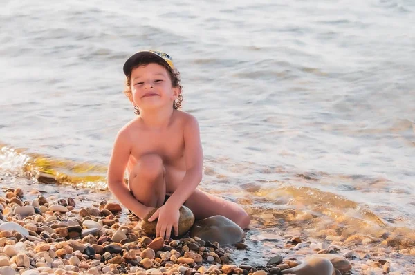 Kleine Jongen Een Kiezelstrand Een Jongetje Zit Het Strand Kijkt — Stockfoto