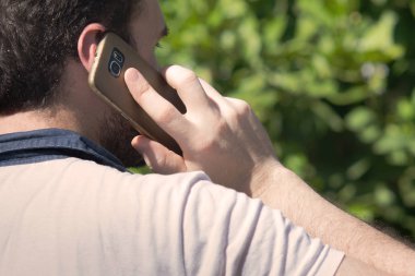 Genç adam ayakta açık havada arama cep telefonu ile