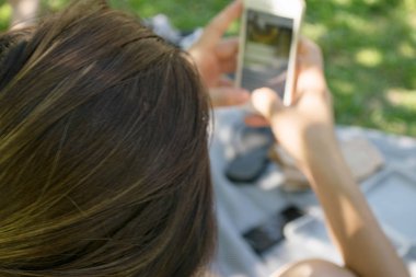 Park adlı akıllı telefon kullanan güzel genç hipster kadın