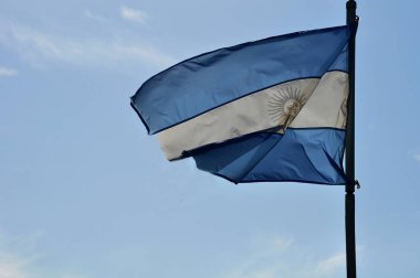 Arjantin bayrağı mavi gökyüzüne karşı güneşli bir günde dalgalanıyor