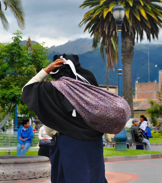 Otavalo, Ekvator - 23 Mart 2016: Otavalo Ana Meydanı'nda renkli bir çanta taşıyor belirsiz Ekvador bir kadın. 71,9 Ekvador insanların % melez etnik grubuna ait