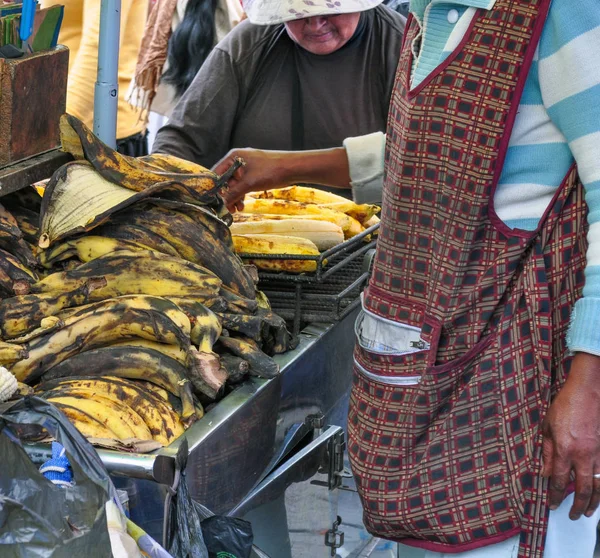 Otavalo, Ekvator - 23 Mart 2016: ızgara maduro (muz) kırsal Cumartesi Pazar 23 Mart 2016 Otavalo, Ekvator üzerinde pişirme bir Ekvador kadın