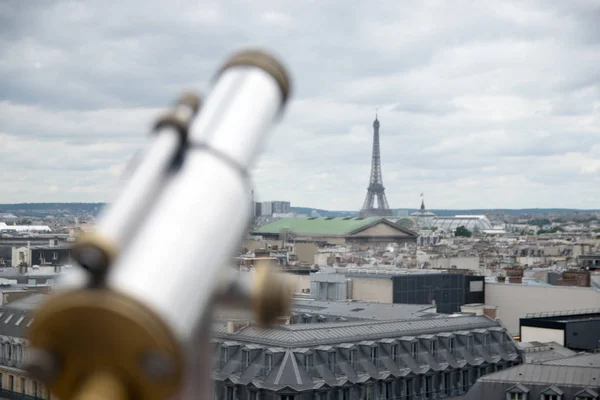 antique telescope with view over Paris, France, at dusk