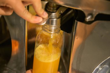 Bir dağıtıcı üzerinden dökülen taze portakal suyu