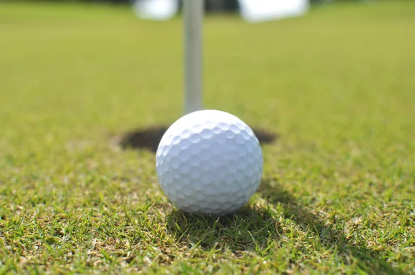 穴の近くに緑のゴルフ ボール — ストック写真