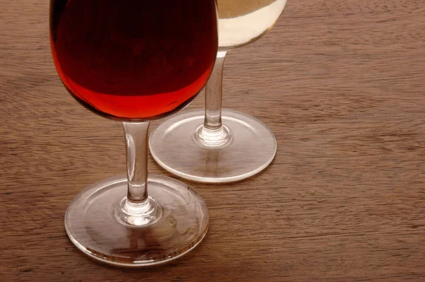 木制桌子上装有红白葡萄酒的酒杯 — 图库照片