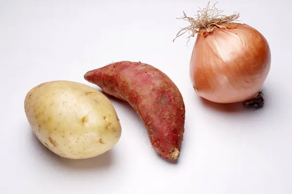 玉ねぎ サツマイモとジャガイモの白い背景に行に — ストック写真