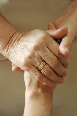 Bir aile üyesinin elini tutan yetişkin bir kadın.