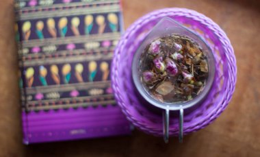 Bir kase aromatik bitkisel çay ve bir dizüstü bilgisayar ya da günlük planlayıcısı