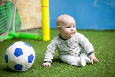 Küçük bir bebek futbolcu bir yeşil eğitim futbol zemin üzerinde