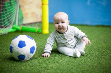 Küçük bir bebek futbolcu bir yeşil eğitim futbol zemin üzerinde