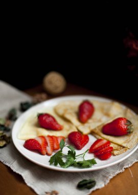 Kahvaltıda taze çilek ile süslenmiş ince Rus krep