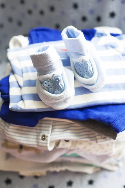 Baby\'s clothes sorted out for a newborn boy in blue and white colors