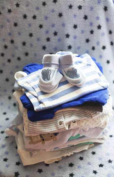 Baby's clothes sorted out for a newborn boy in blue and white colors