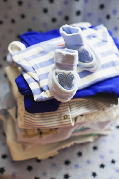 Baby\'s clothes sorted out for a newborn boy in blue and white colors