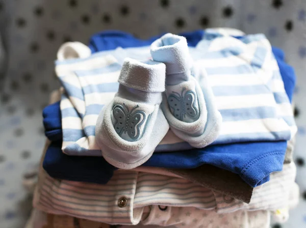 Baby\'s clothes sorted out for a newborn boy in blue and white colors