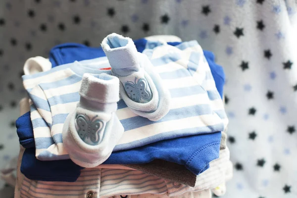 Baby\'s clothes sorted out for a newborn boy in blue and white colors