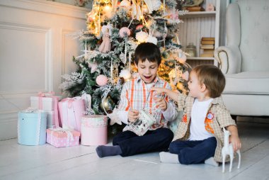 Hediyeleri açma bir köknar ağacı yakınındaki iki erkek