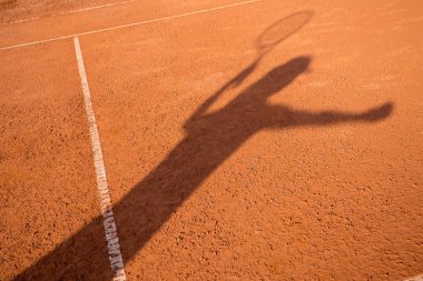 Gölge dışında hizmet veren bir tenis oyuncusu