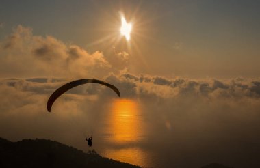 Bulutların üstünde tandem yamaç paraşütü ile güzel gün batımı