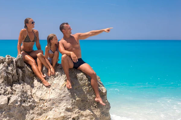 Gelukkige Jonge Familie Zittend Een Rots Het Strand Kijken Naar — Stockfoto