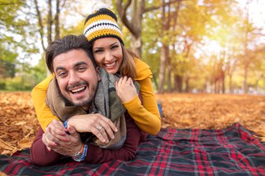 Mutlu çifte bir parkta kameraya gülümseyen sonbahar