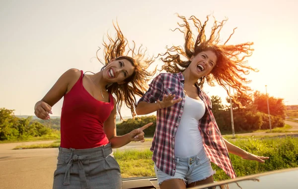 Dos Chicas Hermosas Jóvenes Divirtiéndose Coche Descapotable Agitando Cabeza Mientras — Foto de Stock