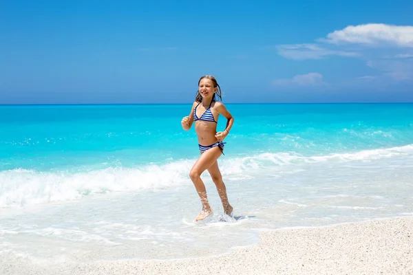 美丽的小女孩在海滩上奔跑白天 — 图库照片