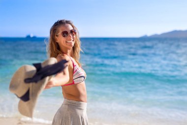 Güzel genç kadın şapka kamerada plaj gündüz atma.