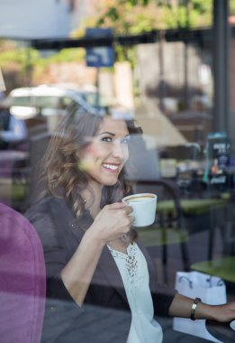 Güzel genç kadın üzerinden dışında yansıması ile fotoğraflandı gülümseyen sırasında kahve içme