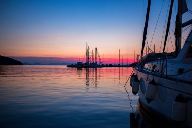 Güzel bir akşam kadeh bir güneş ayarı ile bir tekne okyanusa