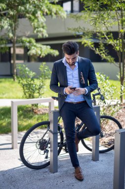 Yakışıklı genç iş adam manifatura üzerinde onun telefon dışında