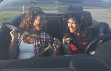 Gülümseyerek emniyet kemeri takarak iki güzel genç kadın