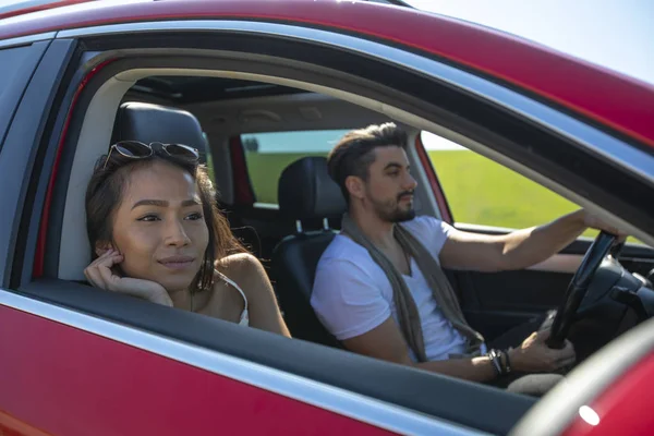 Hermosa pareja joven feliz conduciendo en un viaje en coche — Foto de Stock