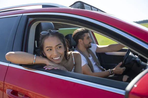Hermosa pareja joven feliz conduciendo en un viaje en coche — Foto de Stock