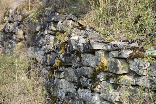 Moss 'lu eski, kuru taş duvar.