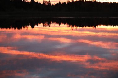  Akşam gökyüzü bir dağ gölüne yansıyor.