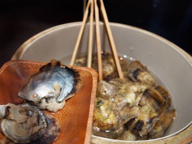 Bir inci bir istiridye kabuğu açılmamış istiridye inci açılış Event'de seçim için kullanılabilir ve büyük bir kova yukarıda ahşap bir tabak içinde görüntülenir. 