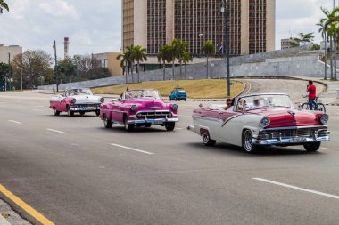 Havana, Küba - 21 Şubat 2016: Renkli vintage arabaya turistler kendi şehir turu üzerinde taşımak. Plaza de la Revoluciön Meydanı.