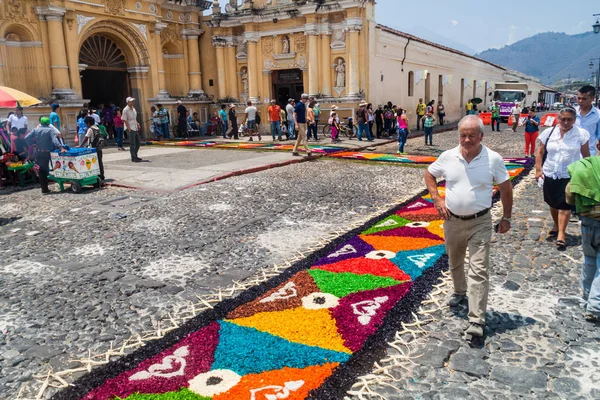 Antigua, Guatemala - 27 Mart 2016: Dekoratif boyunca insanlar yürüyüş Paskalya şehirde Antigua Guatemala, Guatemala San Pedro Apostol Kilisesi önünde halıları.